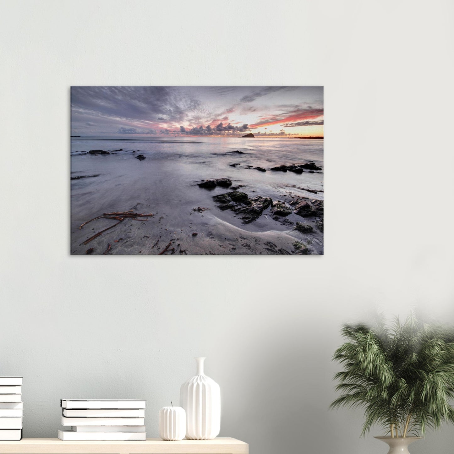 Canvas print of Wembury Beach in Plymouth, Devon, featuring the silhouette of Mewstone at sunset with golden sands, scattered rocks, and driftwood.