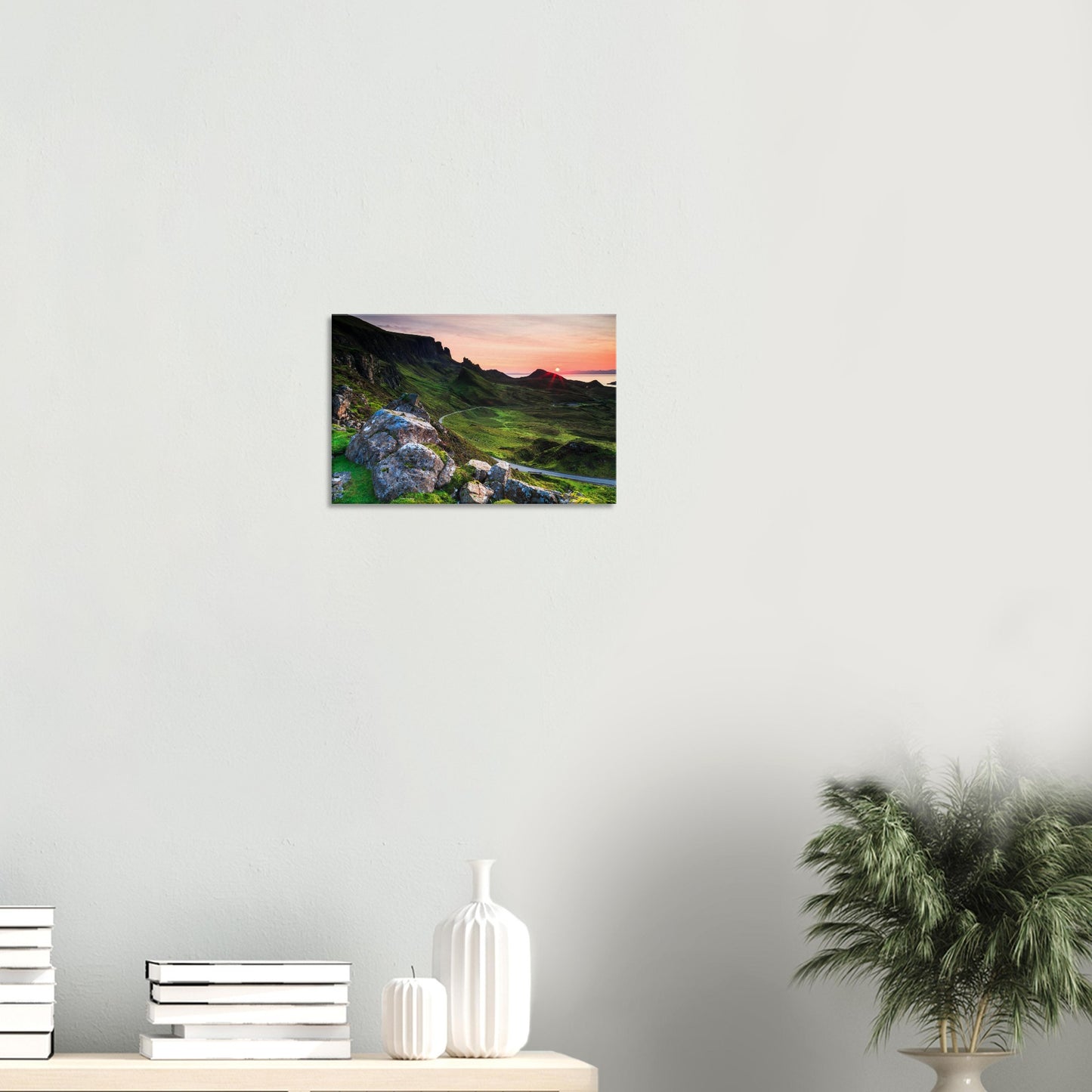 Canvas print depicting The Quiraing’s towering cliffs and rolling green hills under a fiery sunset sky.