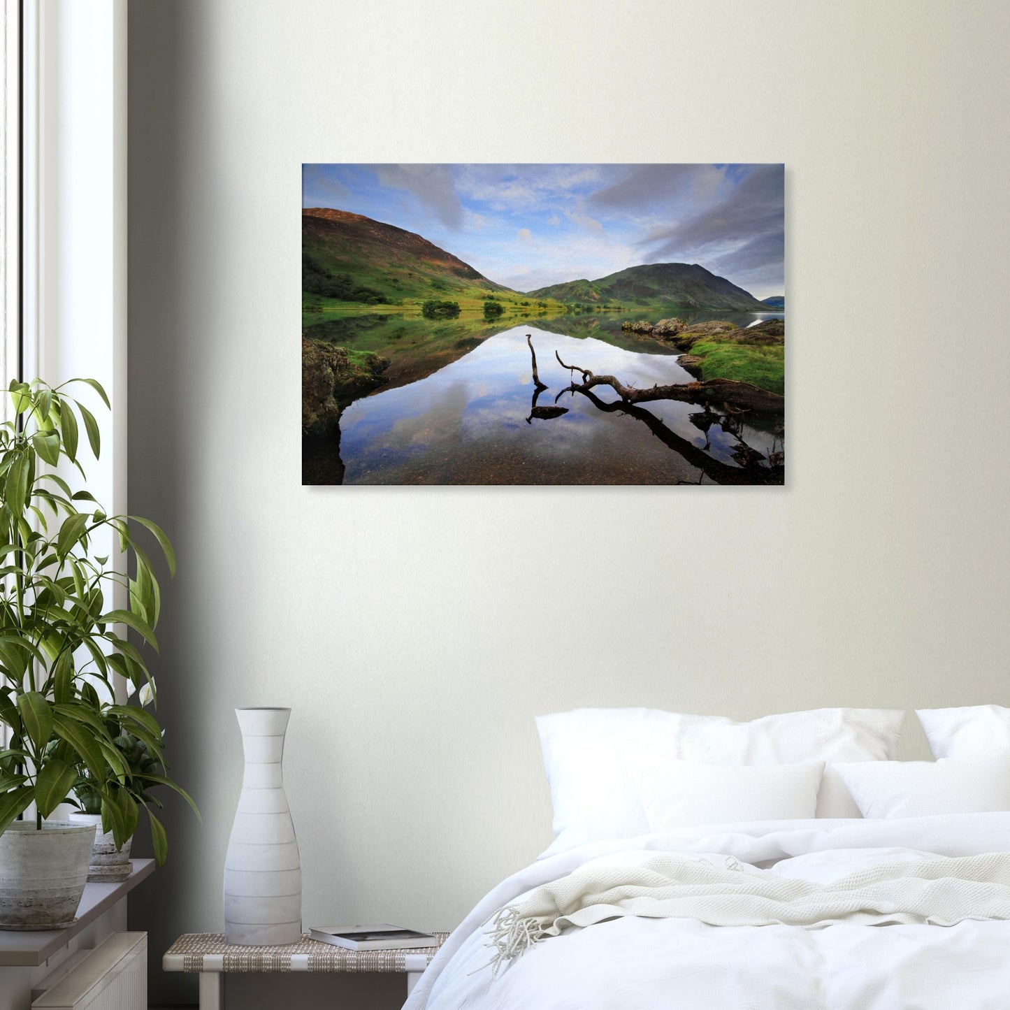 Tranquil Lake District canvas print of Crummock Water featuring a lone branch resting on smooth water and reflections of the sky and hills.