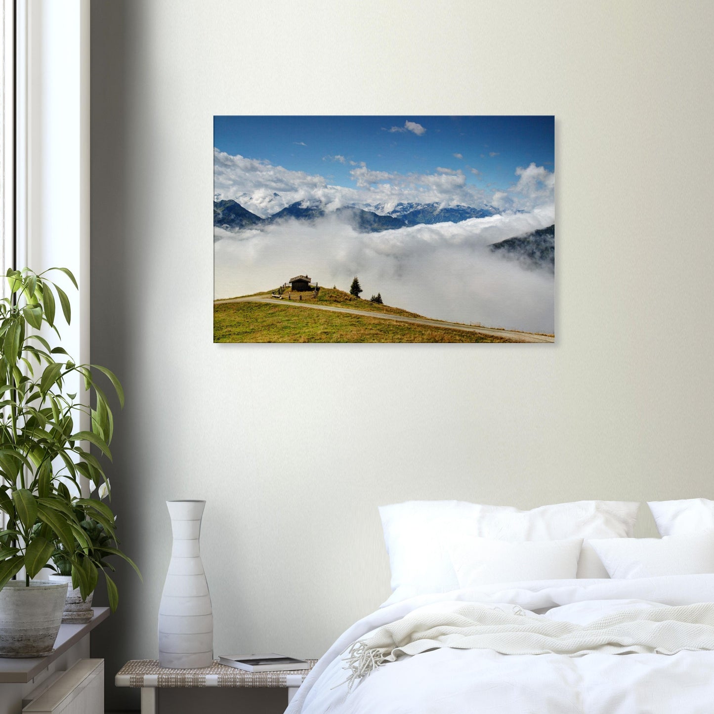 High-altitude canvas of Resterhöhe, Austria, showing dramatic contrast between green hilltop, cloud cover, and jagged snow-capped mountains.