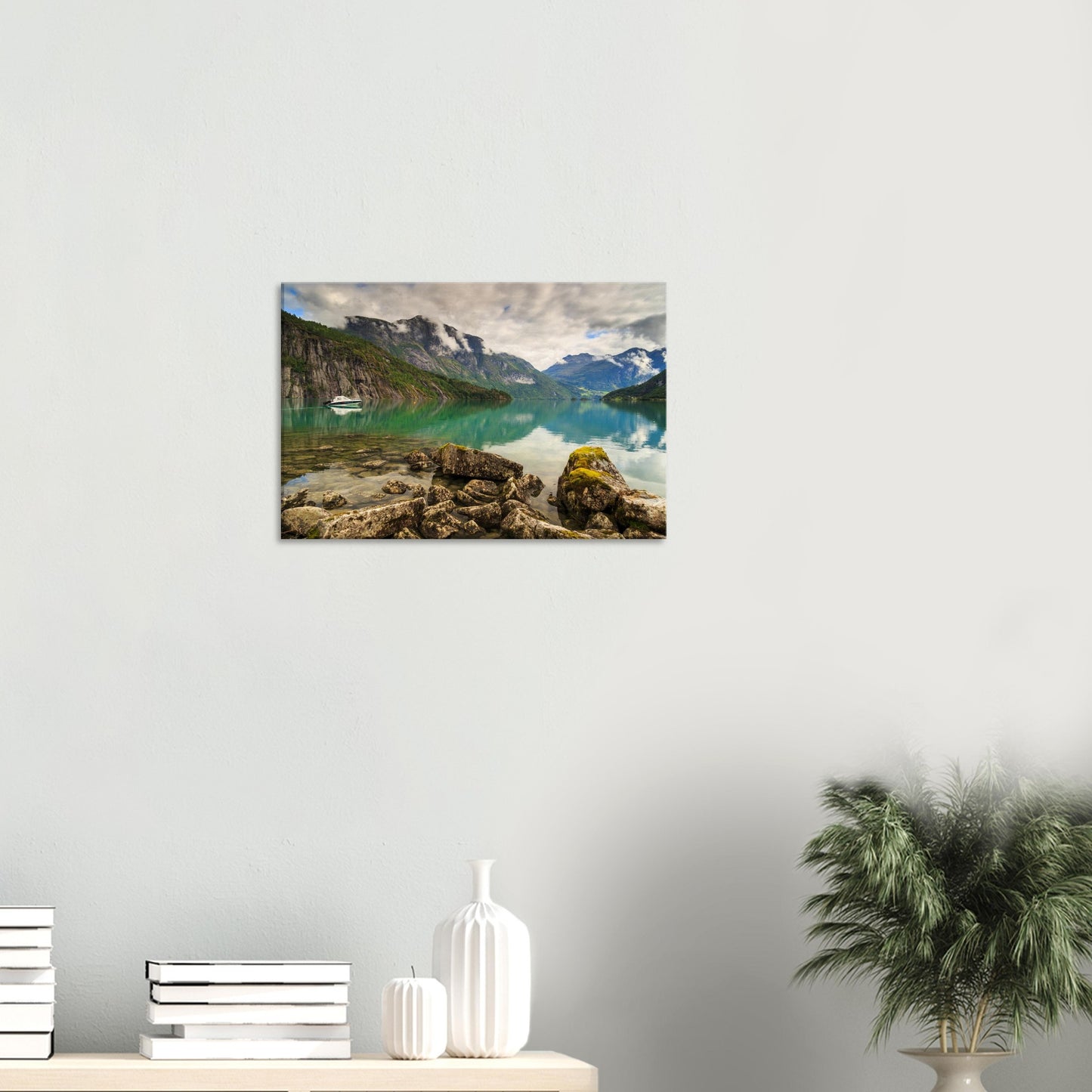 Isolated boat resting gently on still waters beneath majestic cliffs in a peaceful wilderness setting