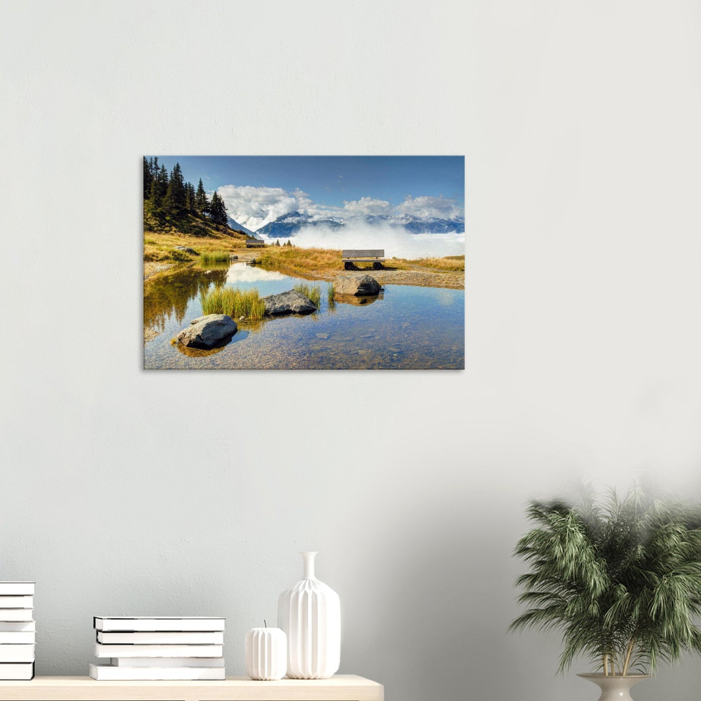Scenic canvas of Resterhöhe showing a still pond mirroring the sky, a lone bench, and alpine mountains rising through low-lying clouds.