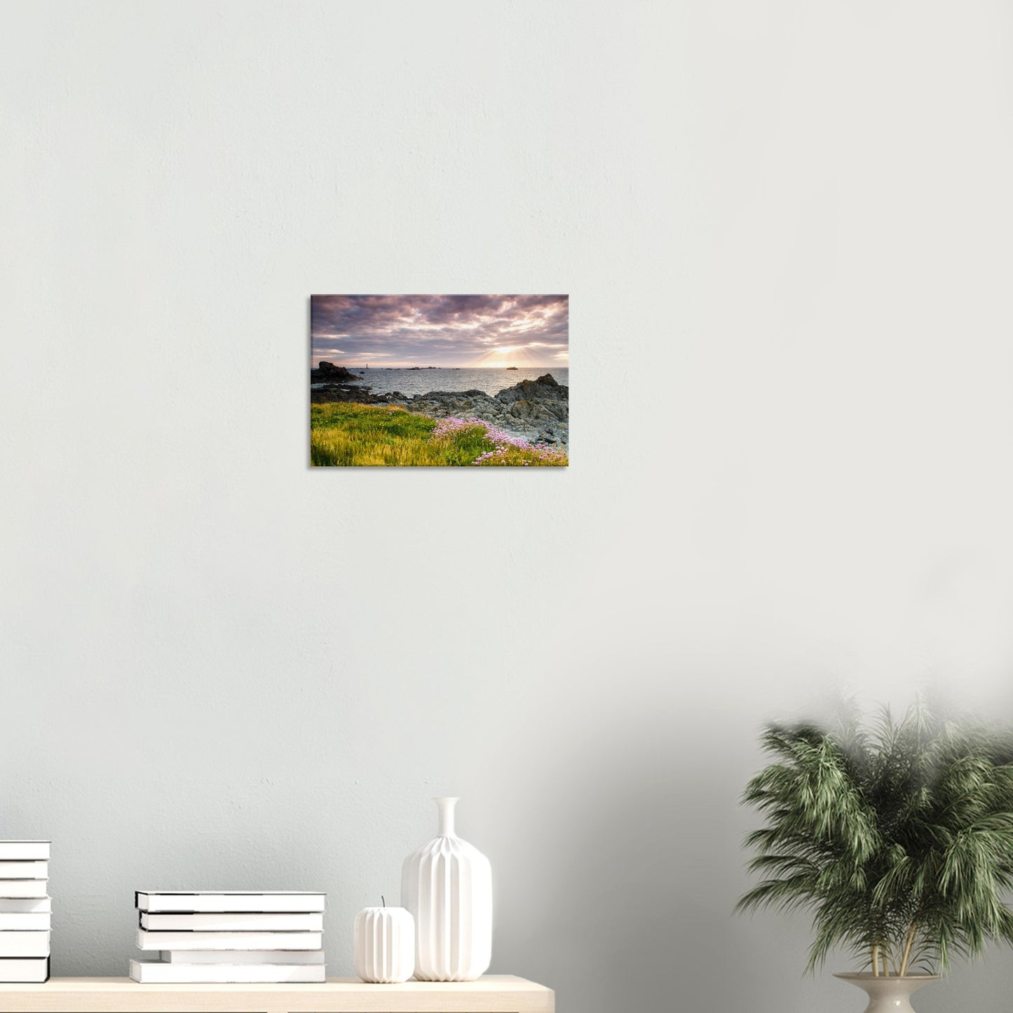 Scenic canvas featuring Pleinmont Point at sunset with wildflowers in the foreground and Les Hanois Lighthouse framed by sunbeams.