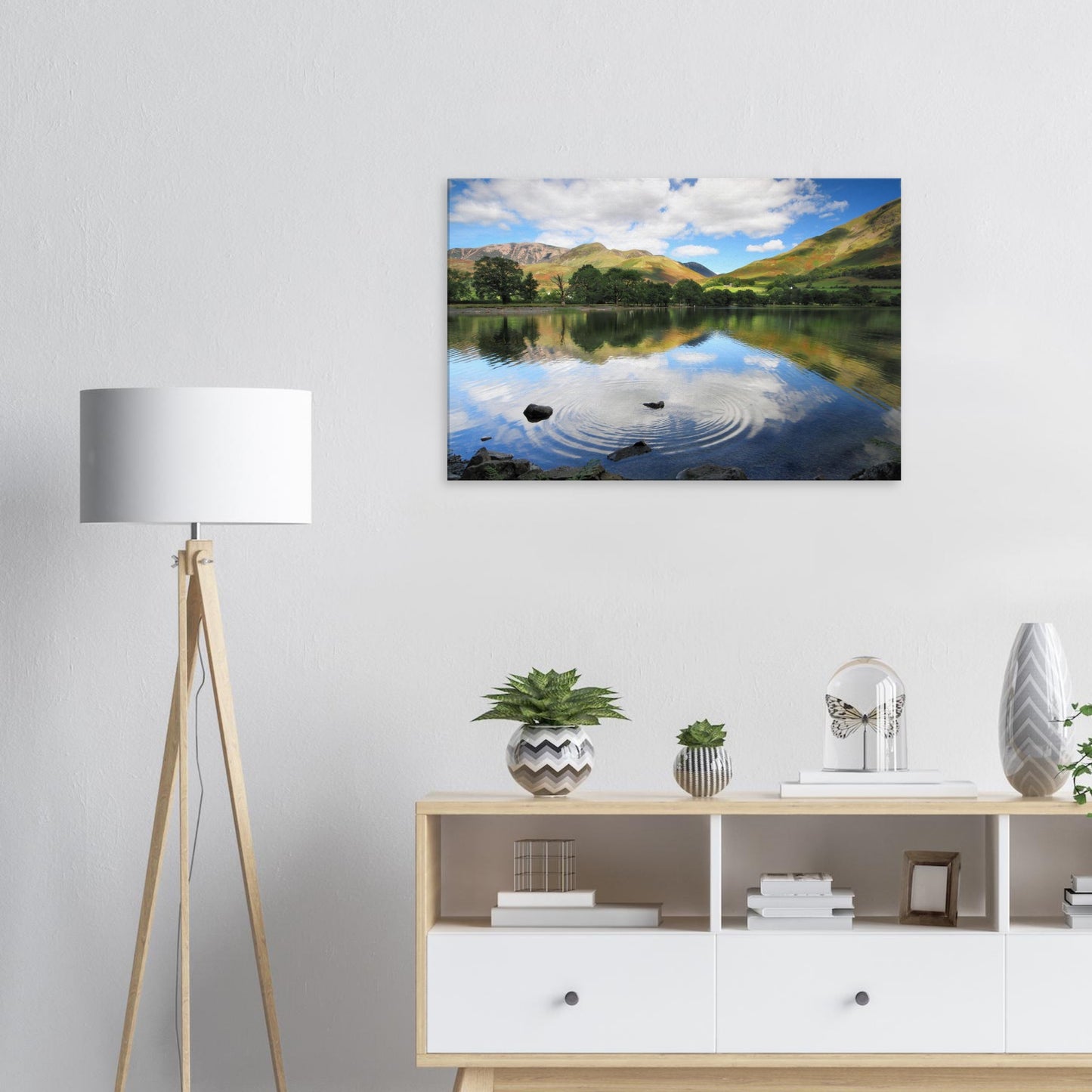Buttermere canvas artwork capturing a quiet lakeside moment with motion on the water, textured slopes, and partial cloud reflections.