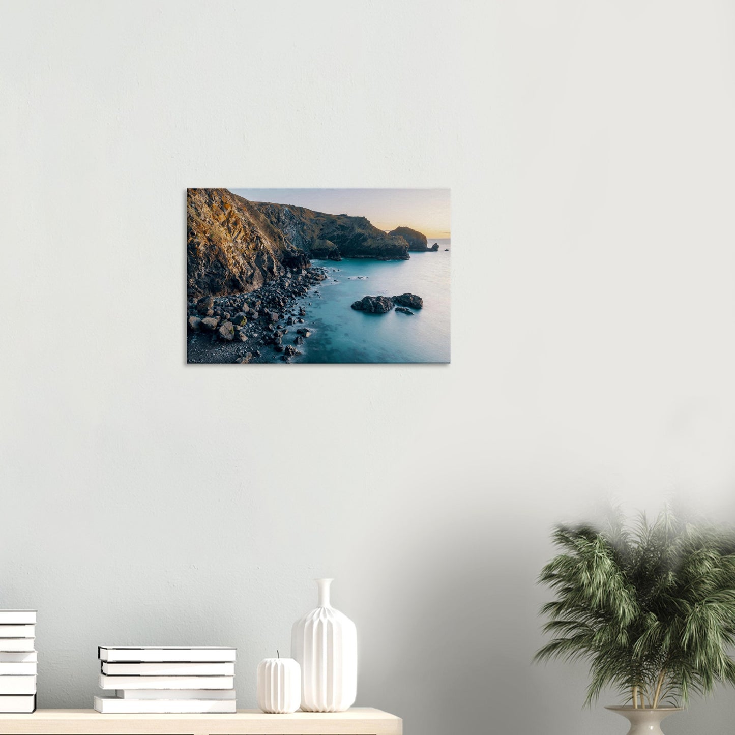 Tranquil coastal landscape in Cornwall as sunset bathes the cove in warm afterglow