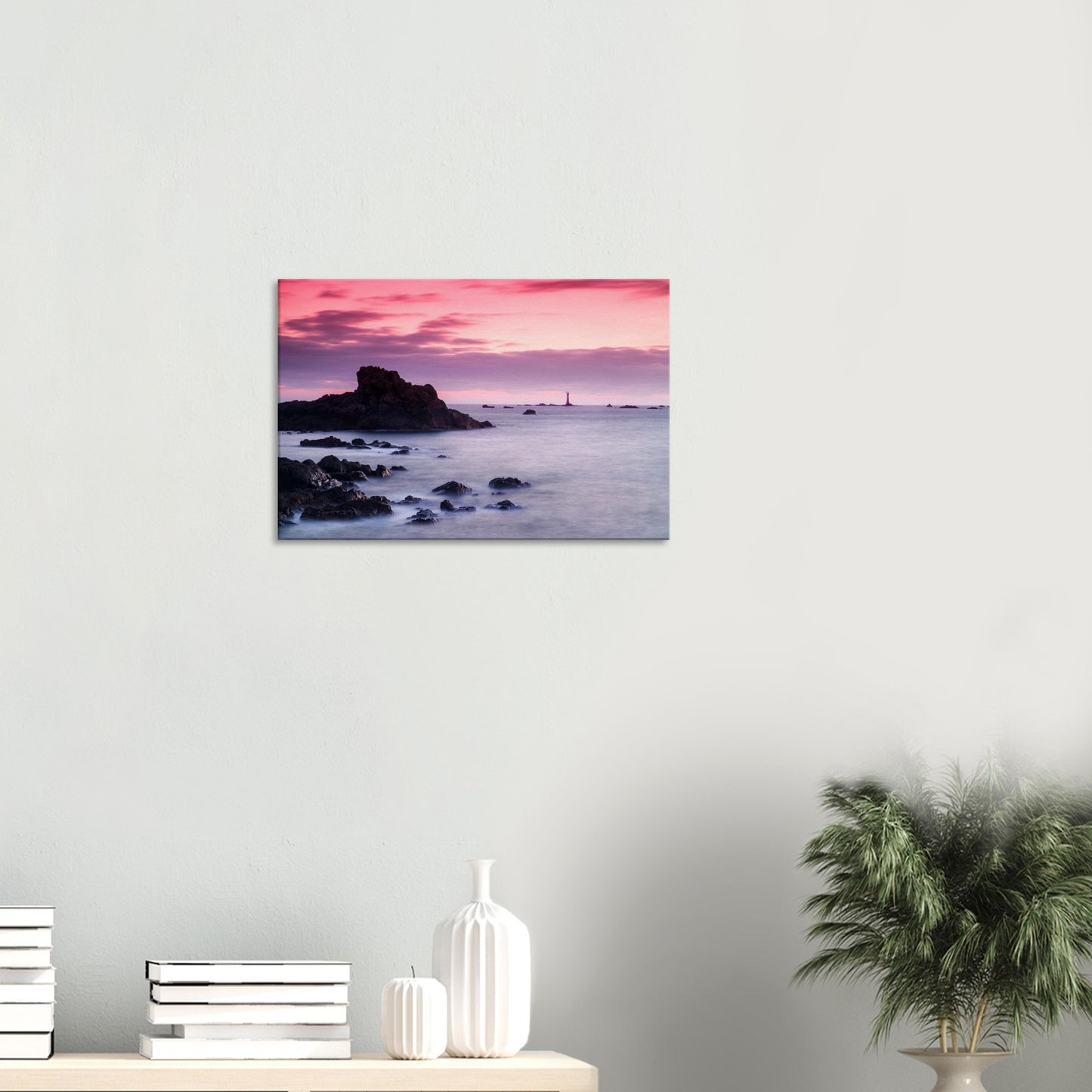 Sunset canvas of Guernsey’s coast with Les Hanois Lighthouse glowing beneath soft twilight hues and a peaceful shoreline.
