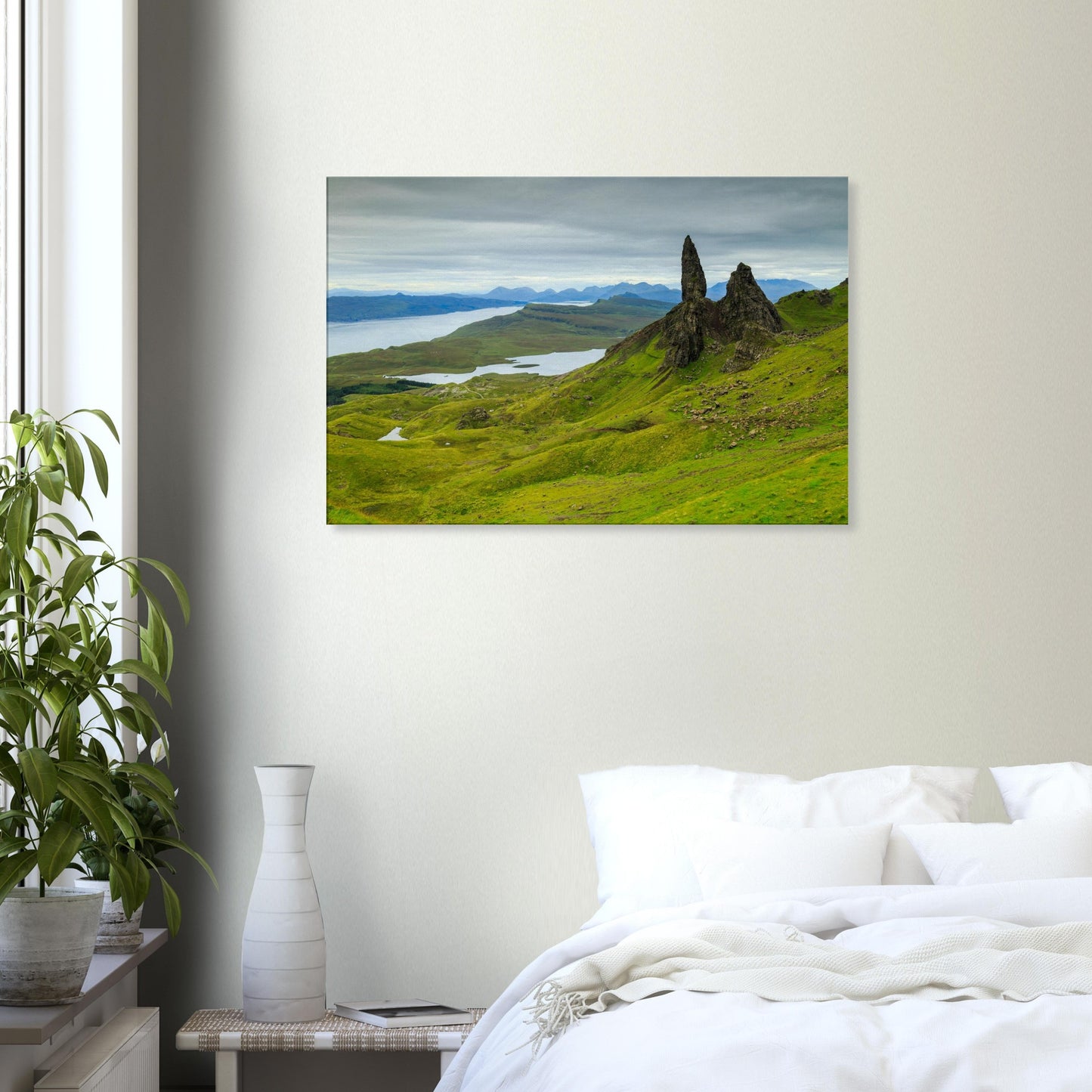 Canvas print showing The Old Man of Storr under atmospheric skies, with undulating terrain leading to the sea.