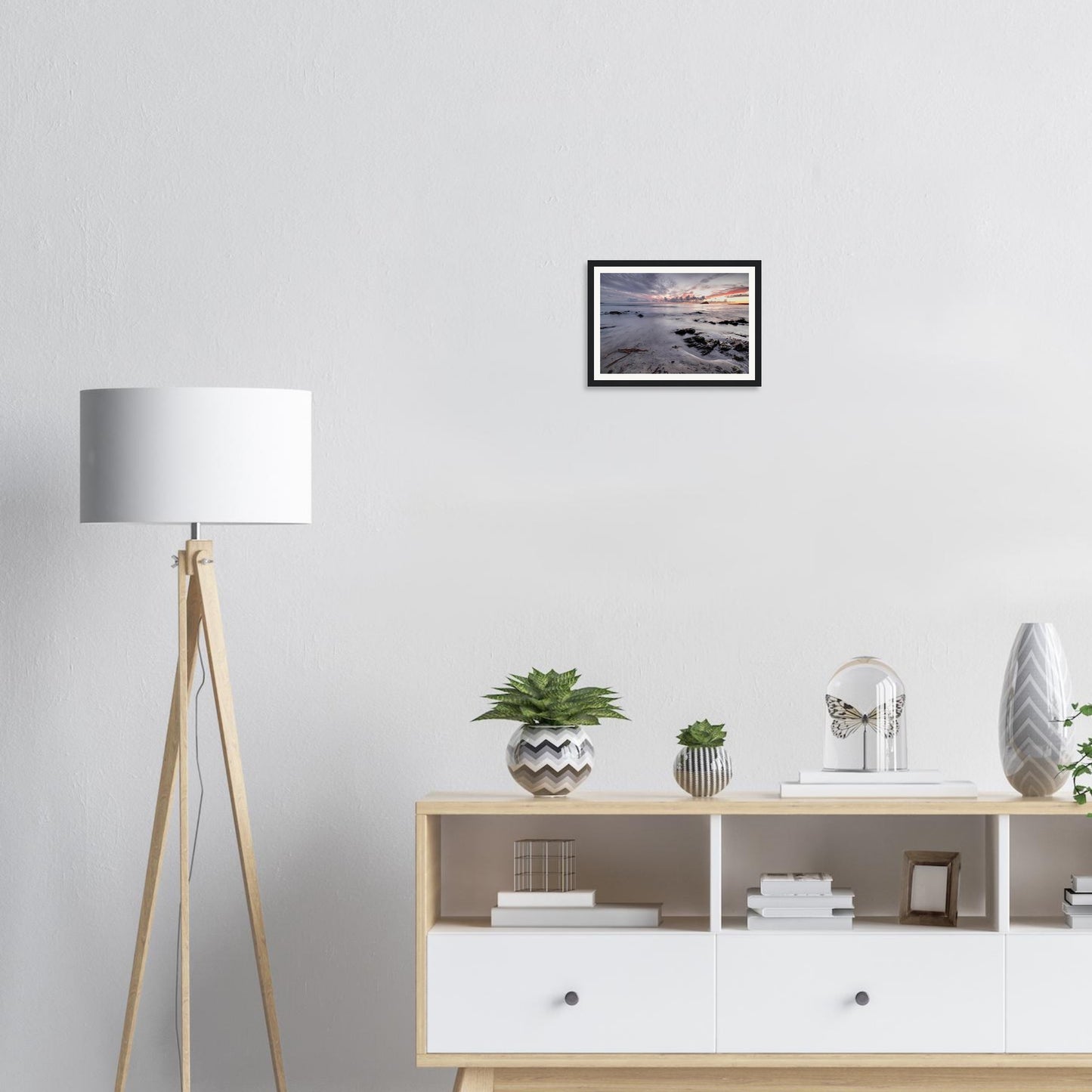 Framed wall art of Wembury Beach with driftwood and rocks