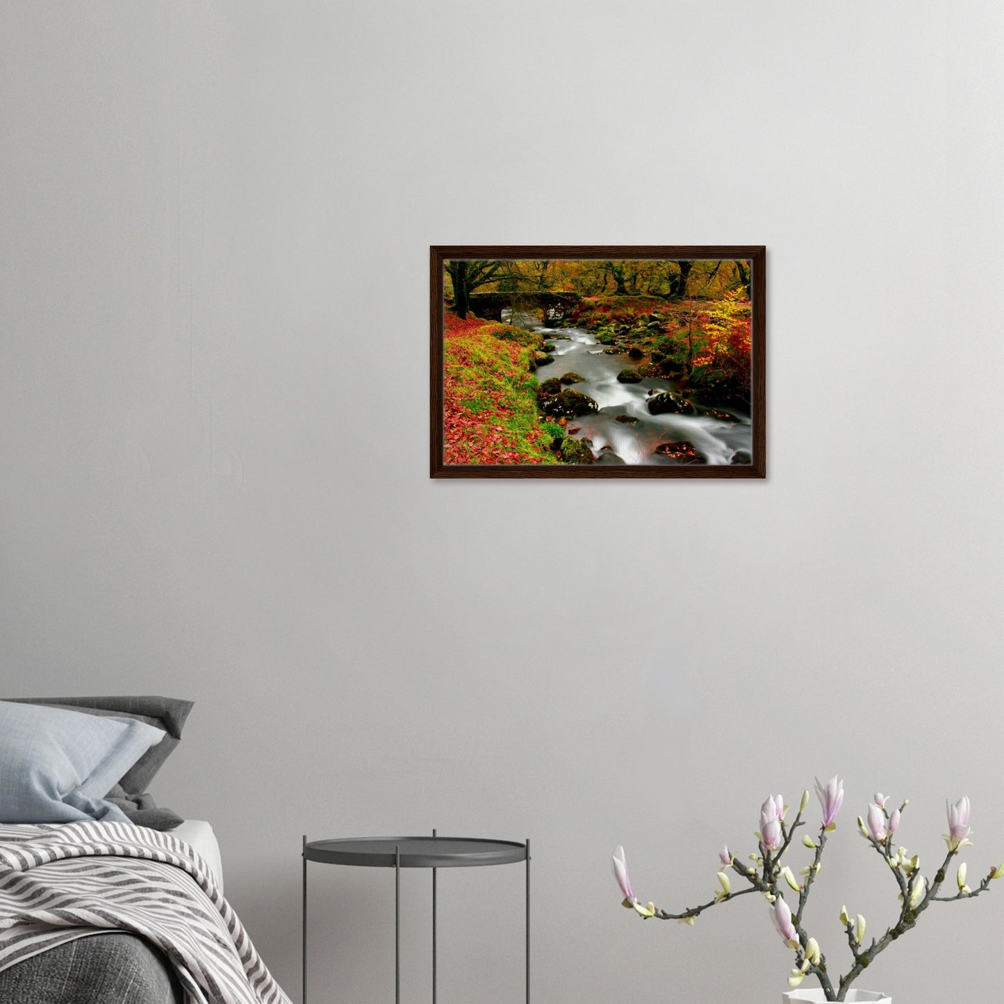 Peaceful woodland stream with moss-covered rocks in autumn colours