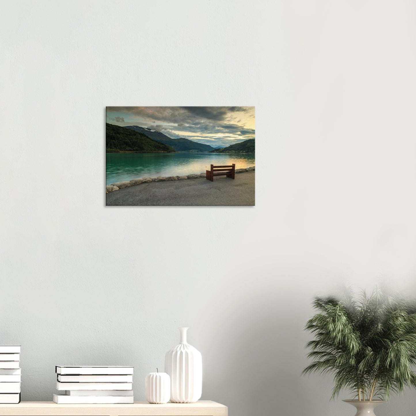Peaceful scene of calm fjord surrounded by gently sloping hills bathed in warm sunset light