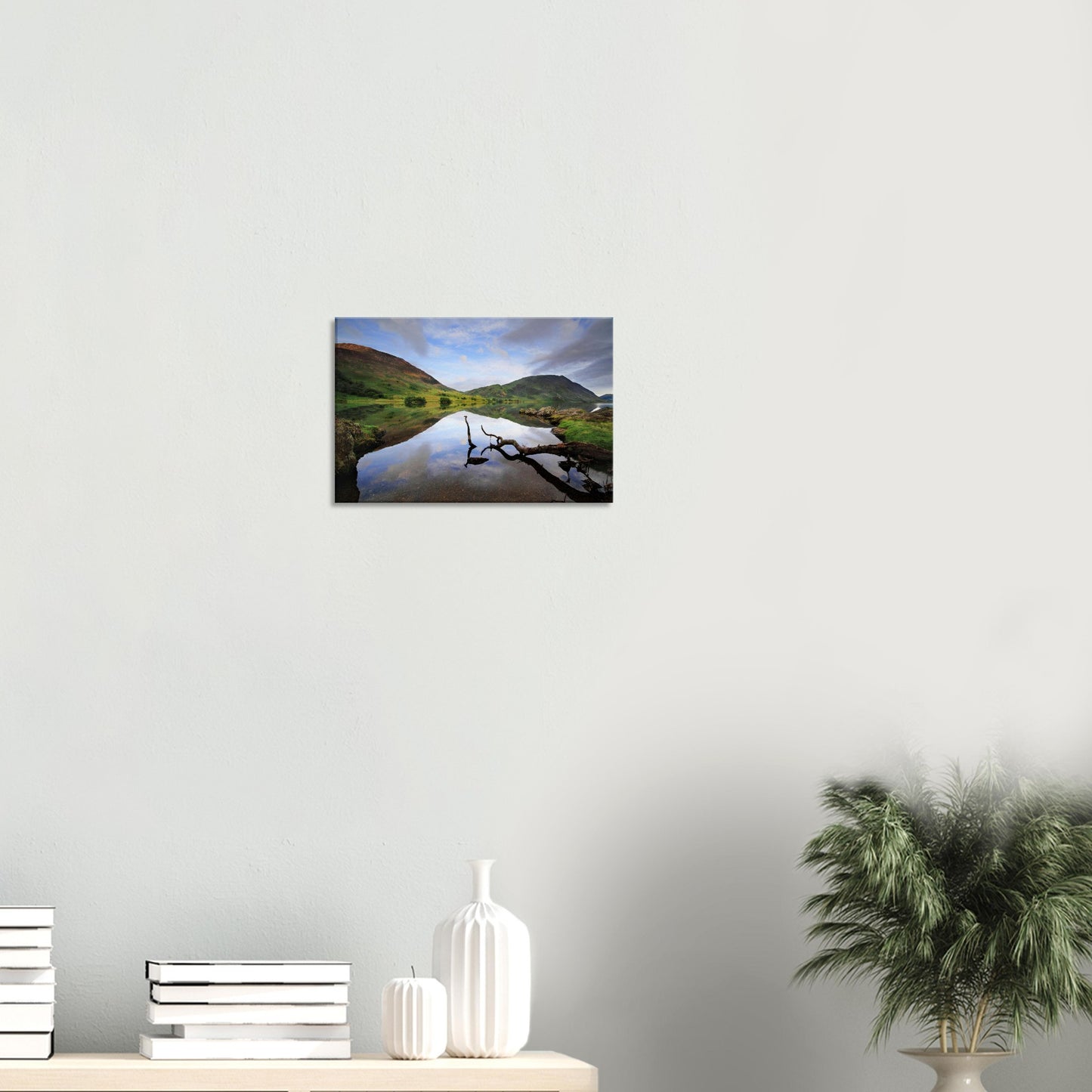 Canvas print capturing the quiet majesty of Crummock Water with a natural branch and still waters reflecting the tranquil Lake District fells.
