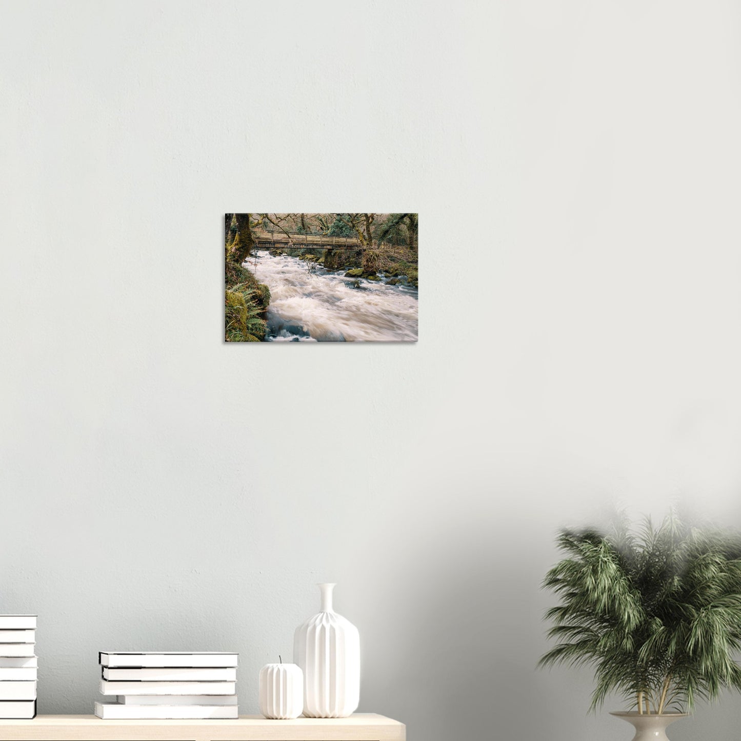 Natural river scene with fast-moving water and a quaint wooden bridge in Dartmoor