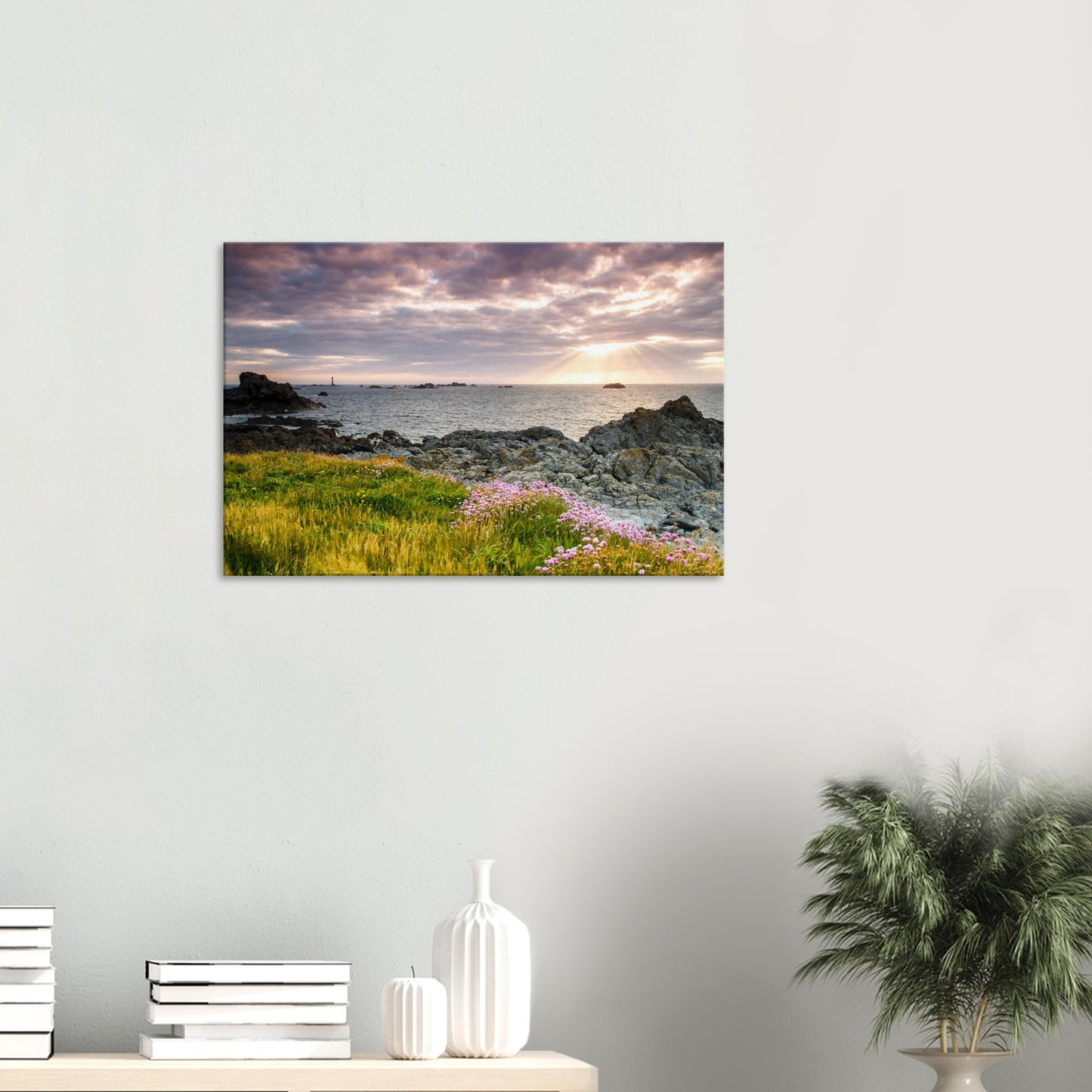 Sunset canvas of Guernsey’s Pleinmont Point, showing sunlit wildflowers, rugged rocks, and Les Hanois Lighthouse under dramatic skies.