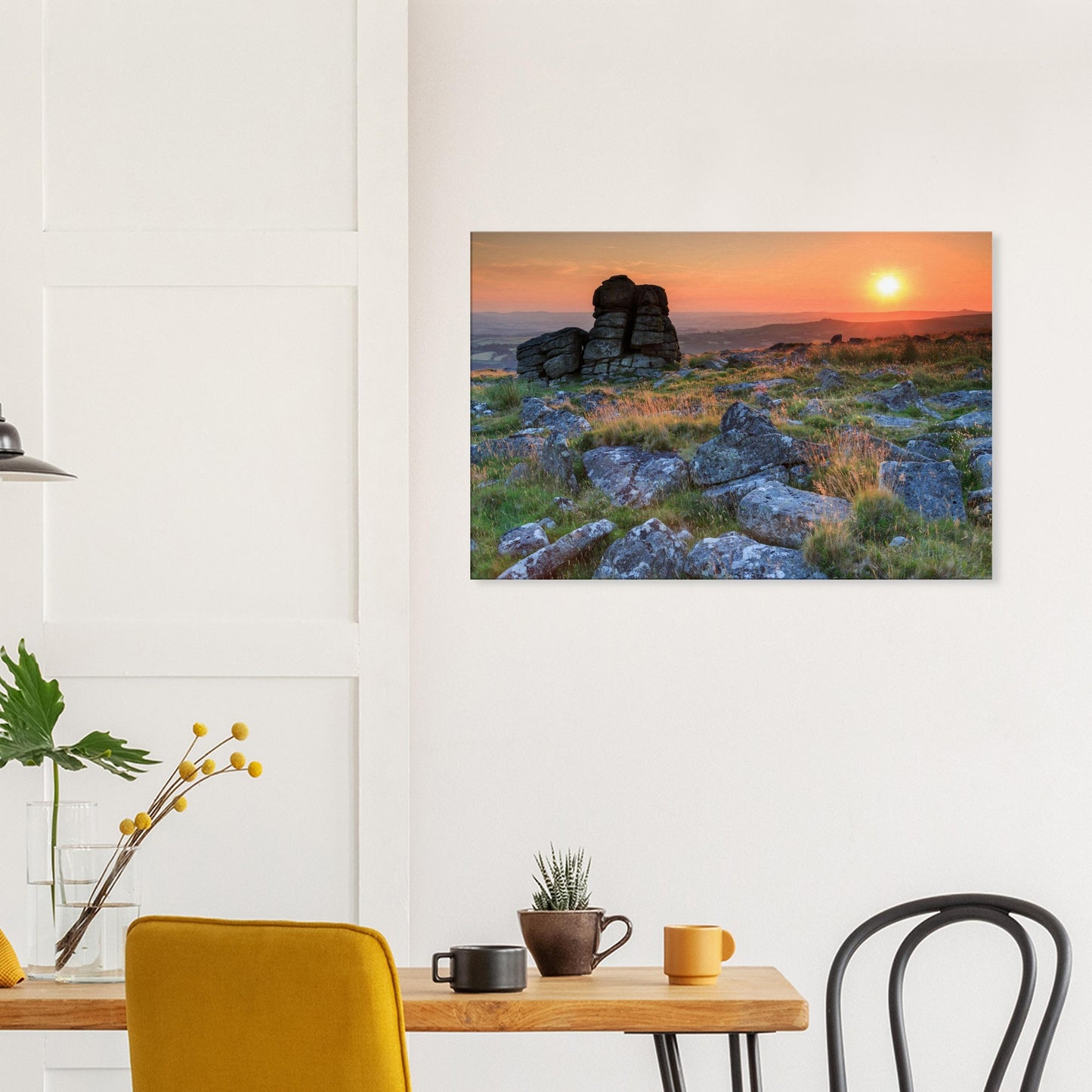 Dartmoor’s iconic granite tor framed by vibrant orange and gold skies at dusk