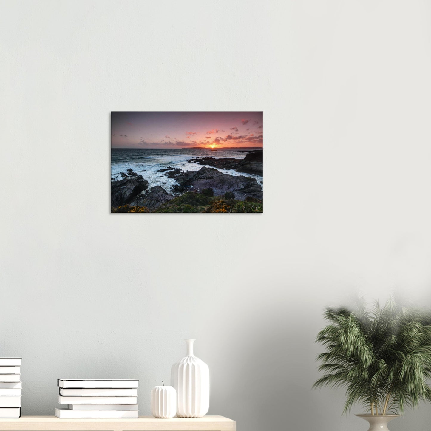 Stunning sunset canvas of Heybrook Bay with warm golden light casting silhouettes over rocky shores and wildflowers swaying in the sea breeze.