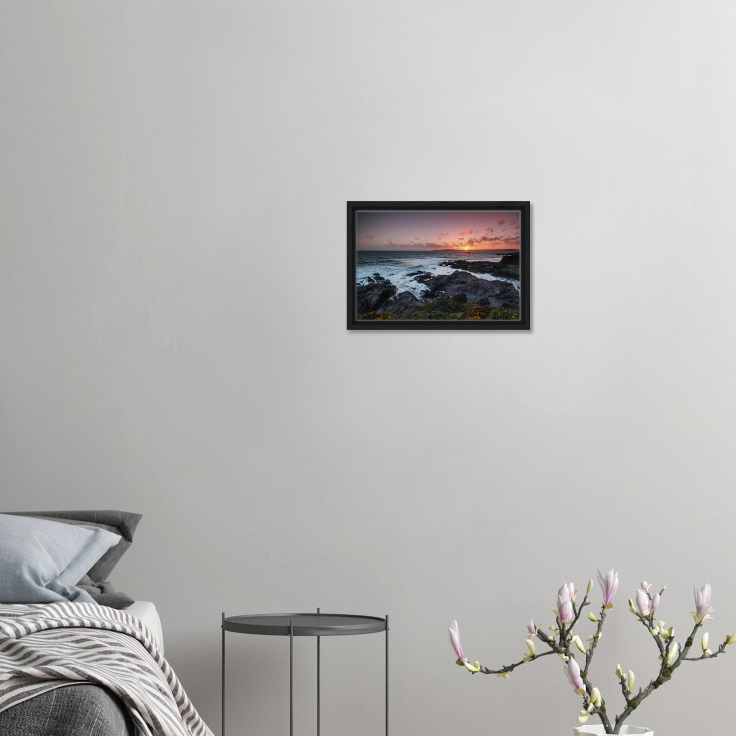 Framed artwork featuring wildflowers and cliffs at sunset