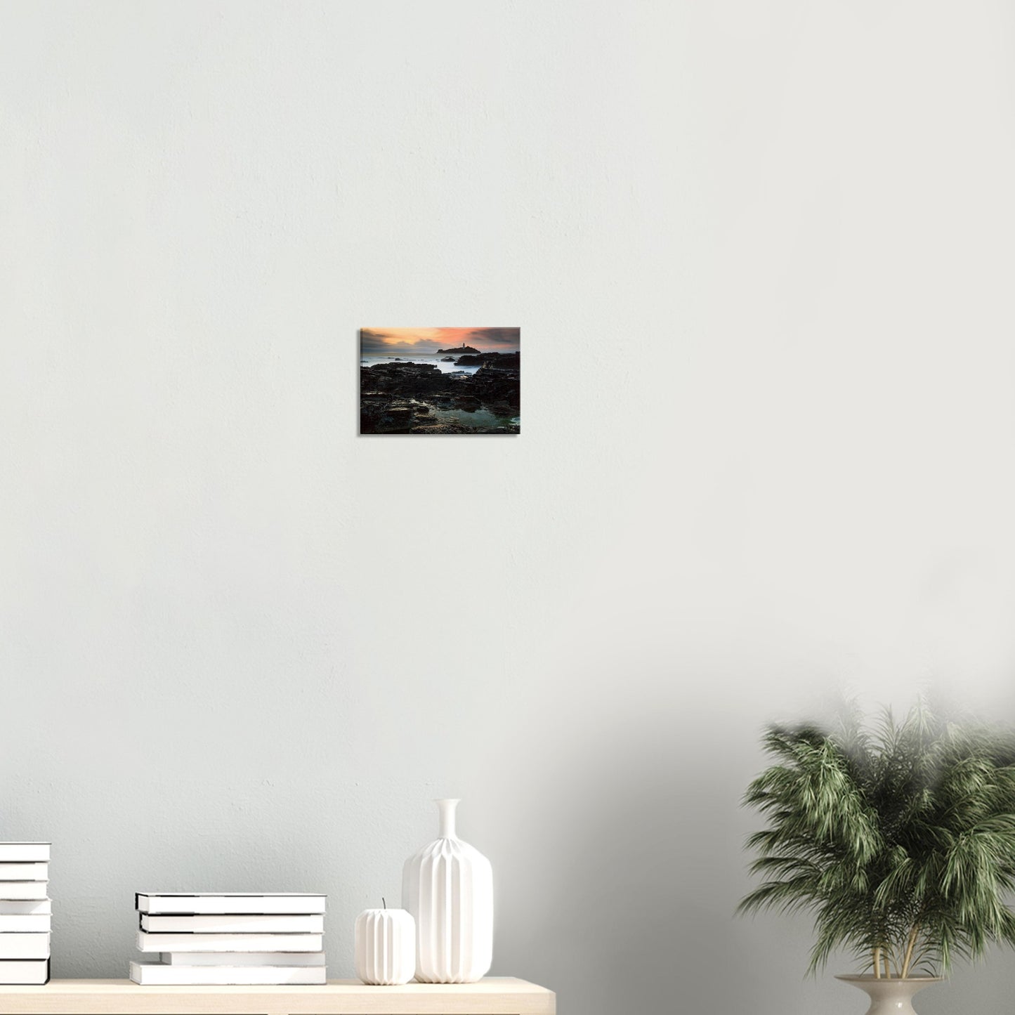 Canvas print of Cornwall coast with historic lighthouse at sunset and glowing rock formations.
