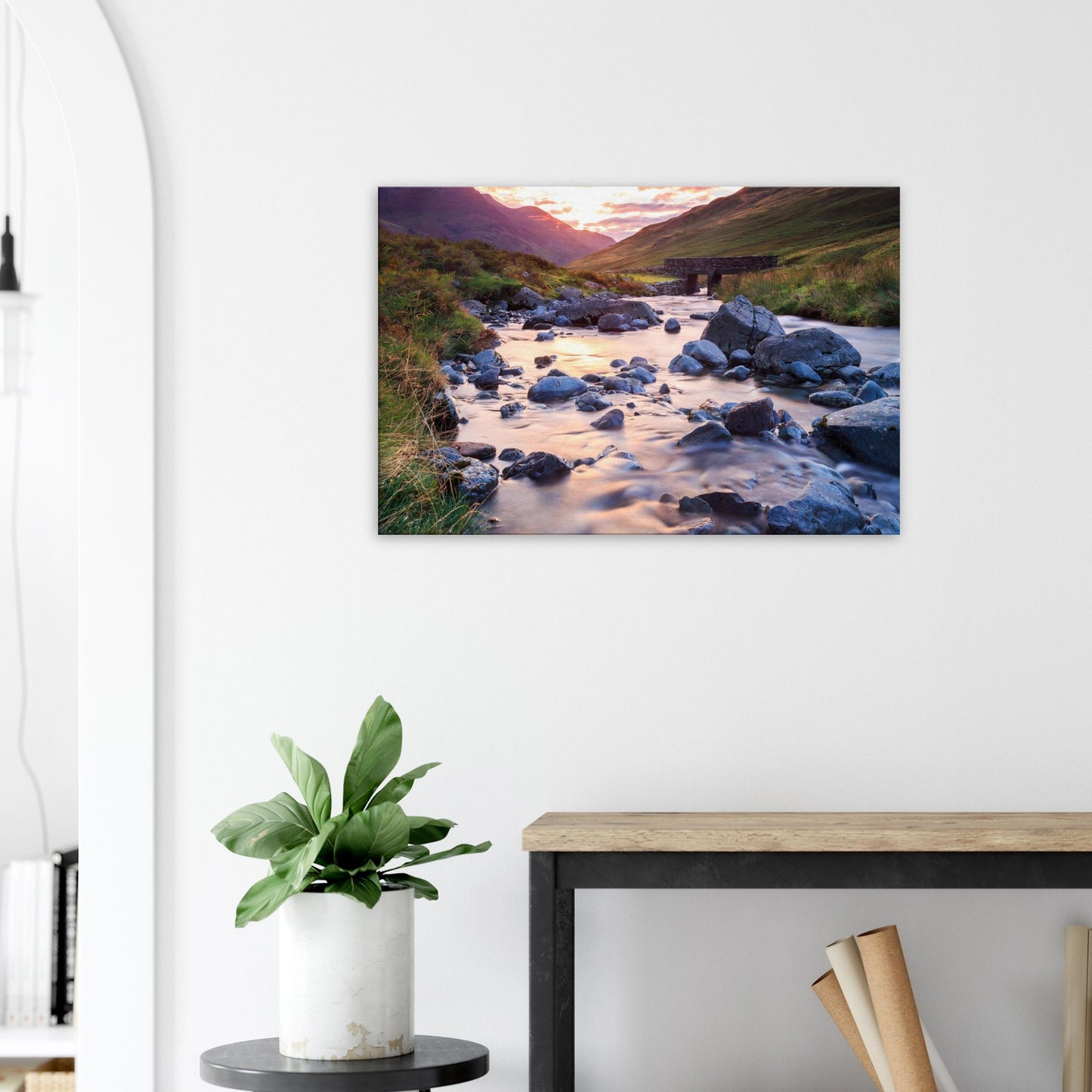 Canvas depicting the quiet beauty of Honister Pass at golden hour with a winding river, stones, and a historic bridge.