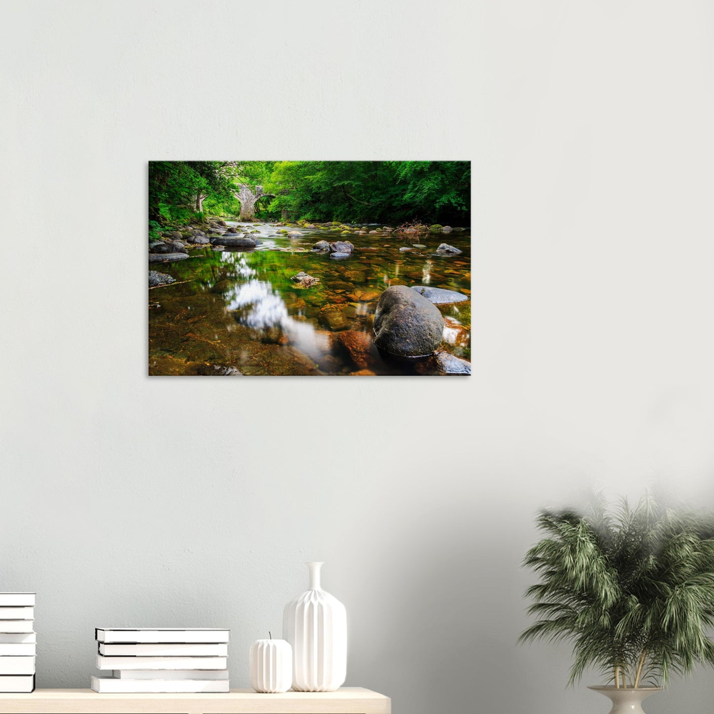 Peaceful riverside setting with light and shadow playing on smooth stones and rippling water
