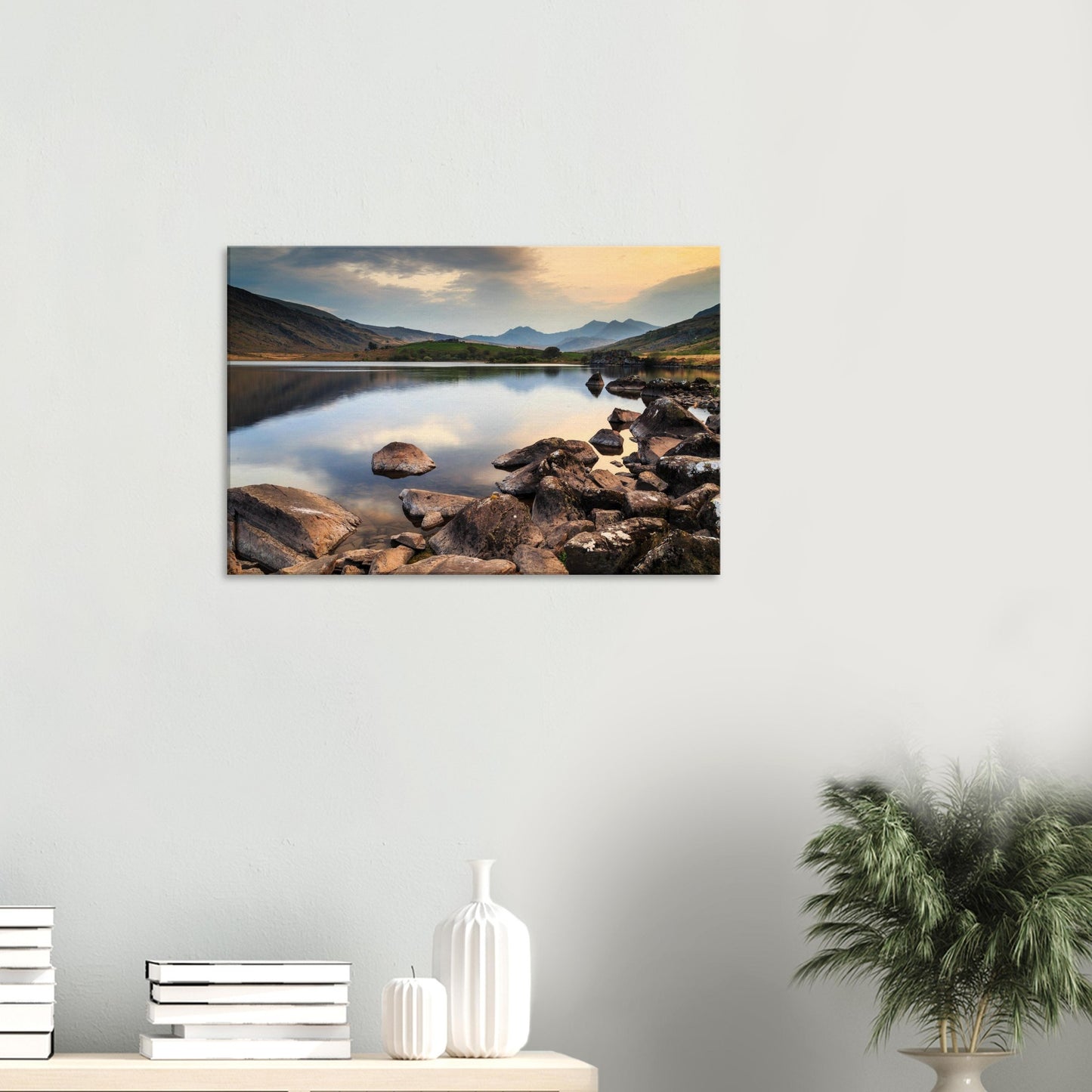 Serene Welsh landscape capturing dusk’s warm glow on still waters and mountainous horizon