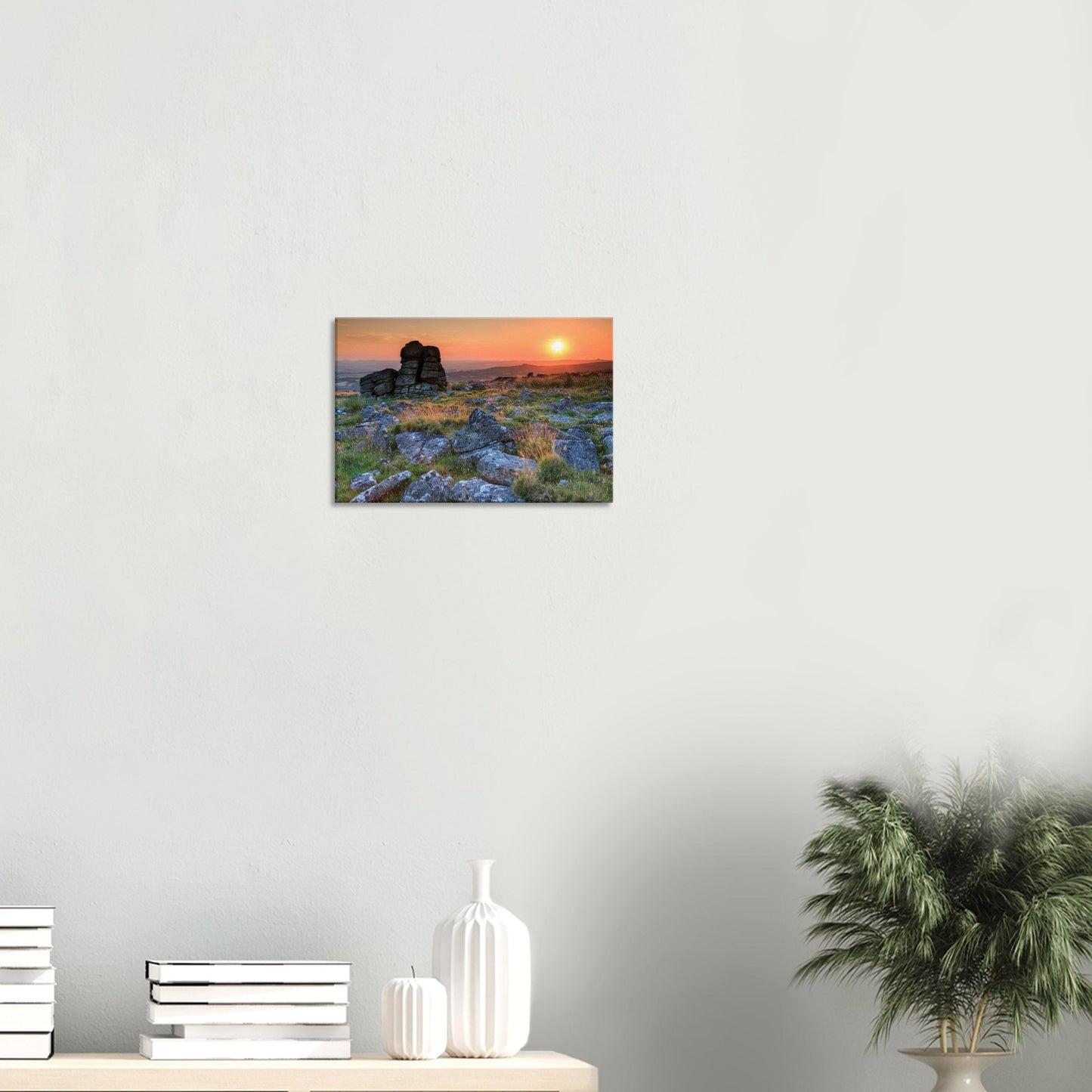 Tranquil moorland foreground with scattered stones illuminated by soft, fading sunlight