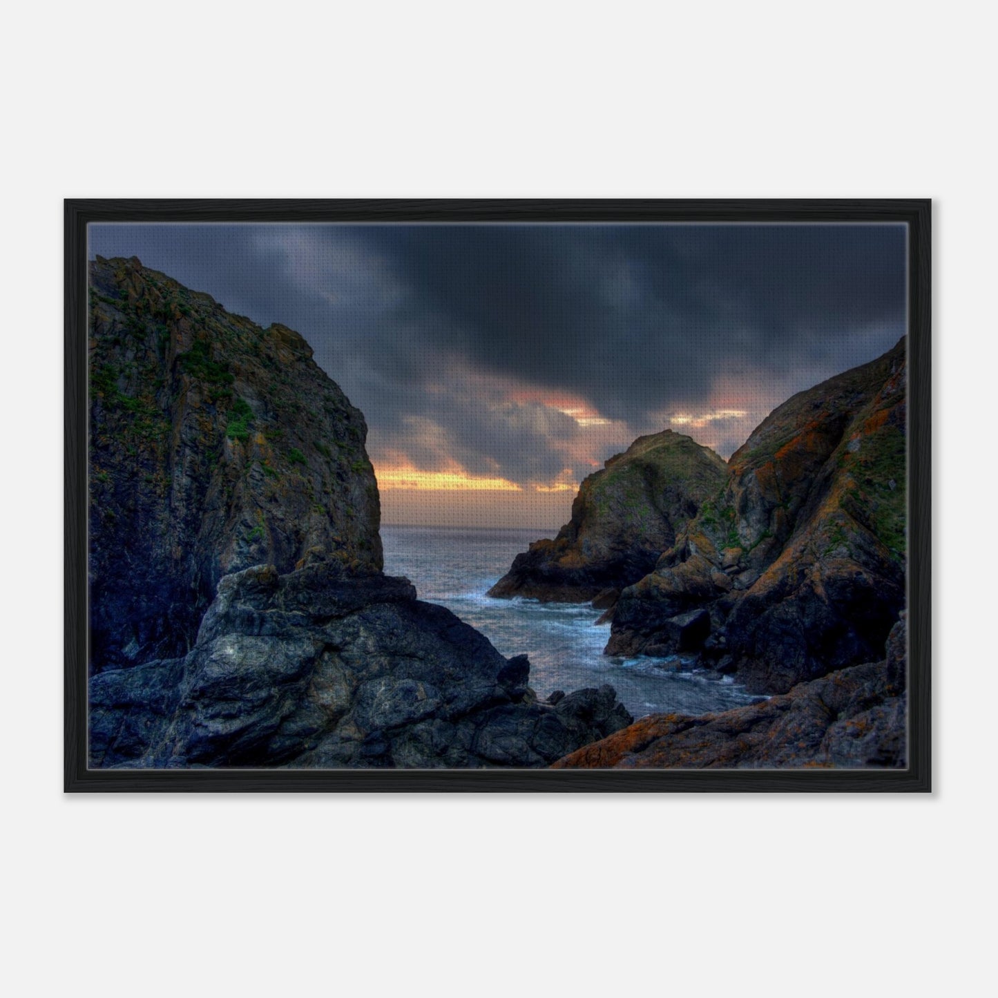 Sunset light on rugged cliffs at Mullion Cove framed canvas