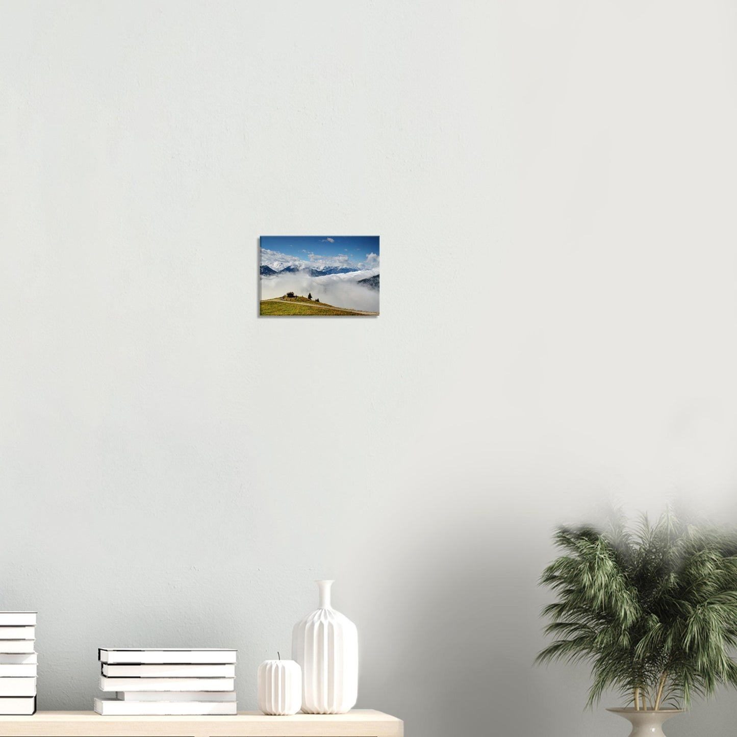 Canvas artwork of the Austrian Alps featuring a hillside hut above the clouds and dramatic alpine peaks in clear morning light.