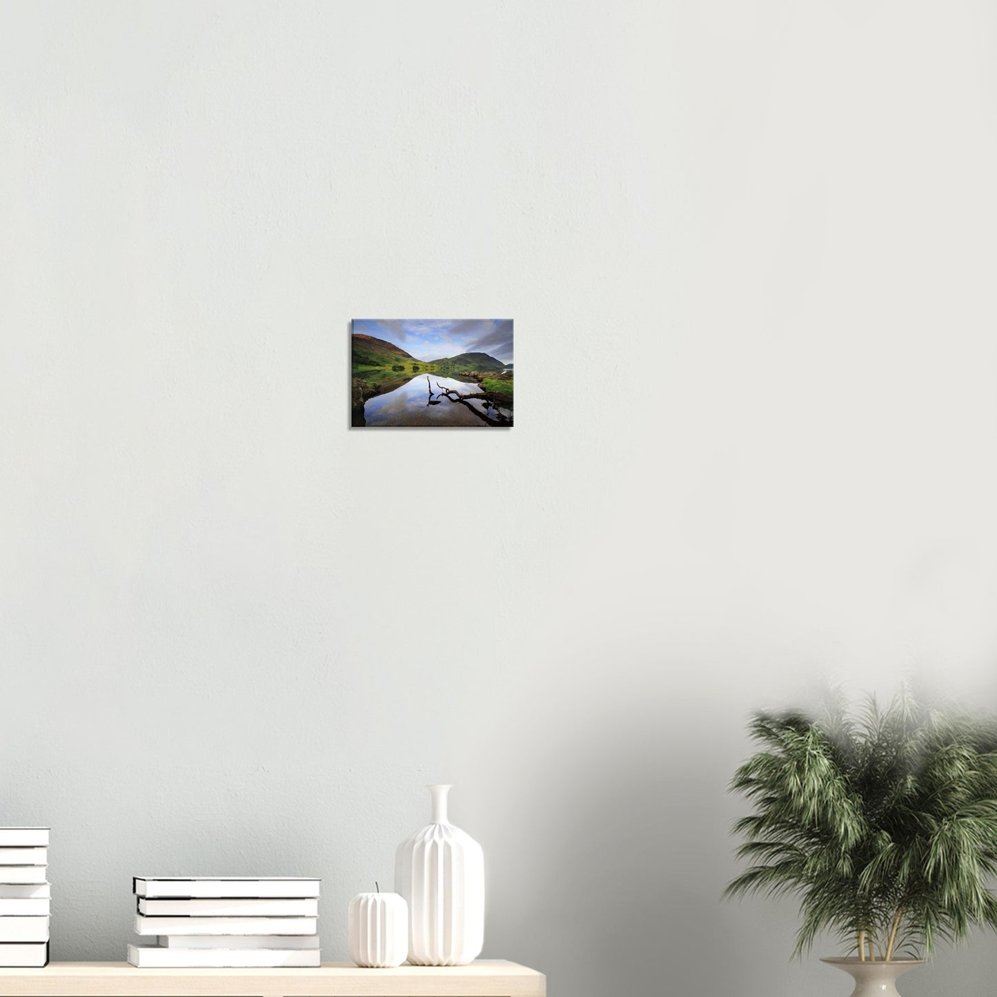 Reflective landscape canvas of Crummock Water featuring a solitary branch in foreground and mirror-like water reflecting hills and soft clouds.