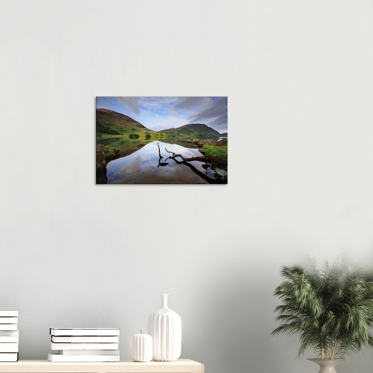 Peaceful canvas print of Crummock Water with a solitary branch in the foreground and smooth lake water mirroring the Lake District fells.