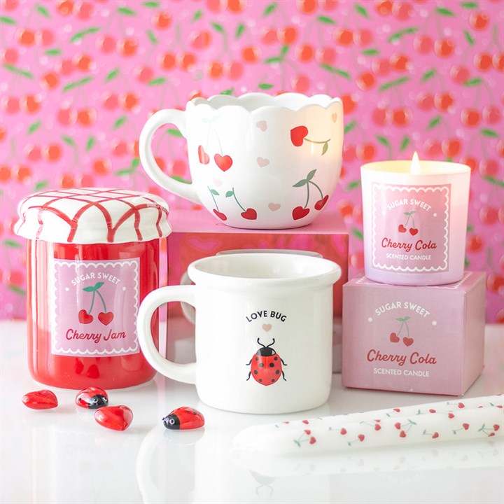 Fall in love with the charming Love Struck collection, featuring delightful gifts like cherry-themed candles, playful mugs, heart-inspired accessories, and whimsical oil burners.