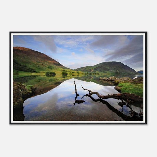 Still waters of Crummock Water mirroring fells and sky in Cumbria