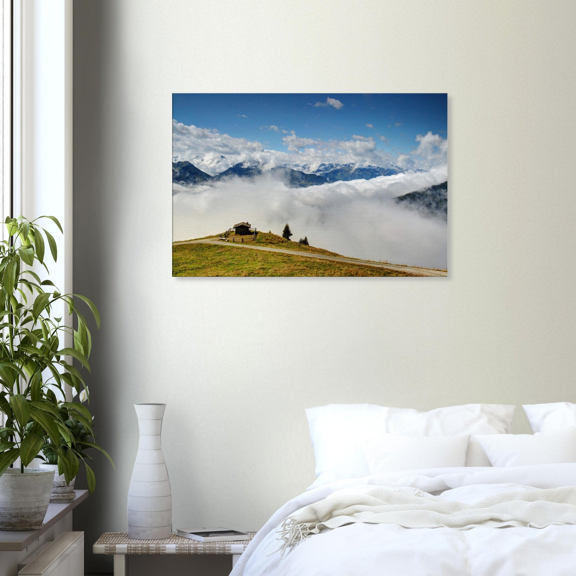 High-altitude canvas of Resterhöhe, Austria, showing dramatic contrast between green hilltop, cloud cover, and jagged snow-capped mountains.