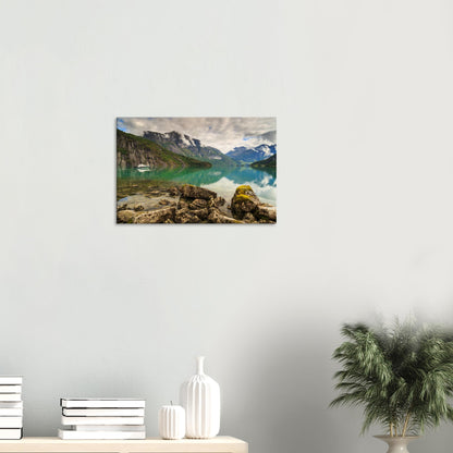 Isolated boat resting gently on still waters beneath majestic cliffs in a peaceful wilderness setting