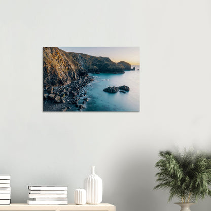 Mullion Cove at dusk with sunlit cliffs and peaceful ocean reflections