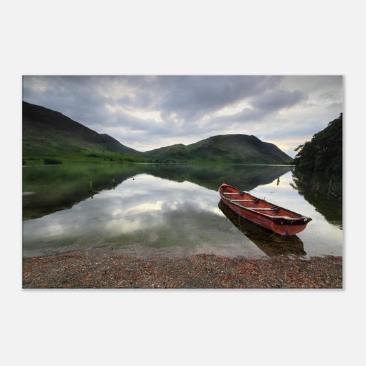 Solitary red boat on the shore of Crummock Water in Cumbria