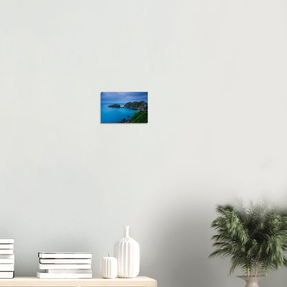 Scenic canvas artwork showing Lundy Island’s rugged coastline at dusk, with a lighthouse and serene waters under a soft blue sky.