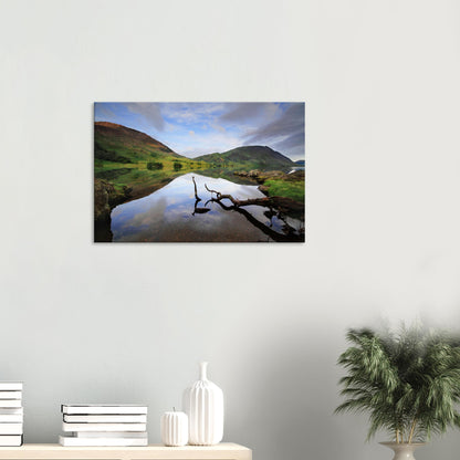 Calm canvas artwork of Crummock Water with a lone branch floating on the lake, surrounded by reflections of the surrounding landscape.