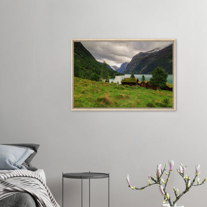 Traditional grass-roof cabins by lake in Norwegian landscape