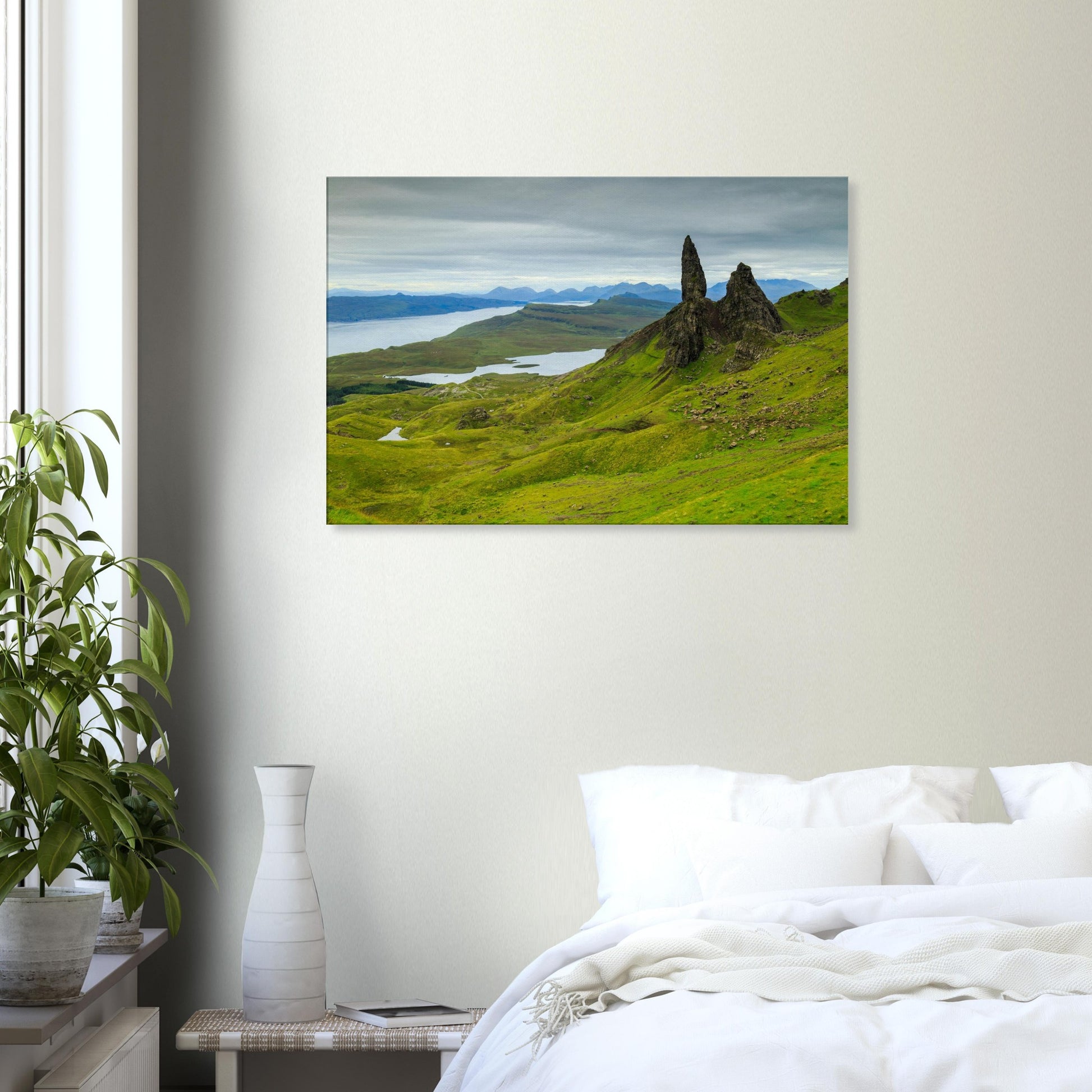Canvas print showing The Old Man of Storr under atmospheric skies, with undulating terrain leading to the sea.