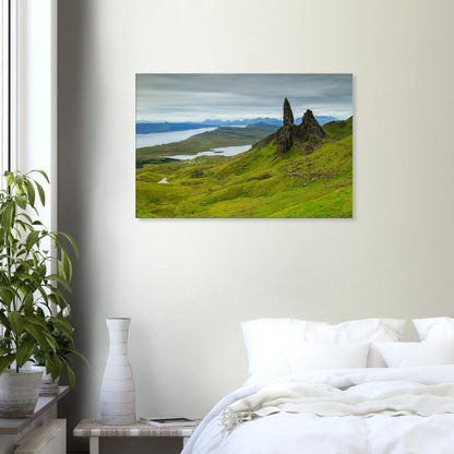 Canvas print showing The Old Man of Storr under atmospheric skies, with undulating terrain leading to the sea.