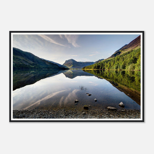 Still waters of Buttermere mirroring fells and sky in Cumbria