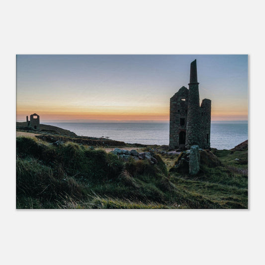 Historic Cornish mine ruins of Wheal Owles lit by soft sunset light in Botallack