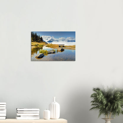 Alpine landscape canvas featuring a calm pond, empty bench, and rolling clouds at the foot of rugged peaks in Resterhöhe.