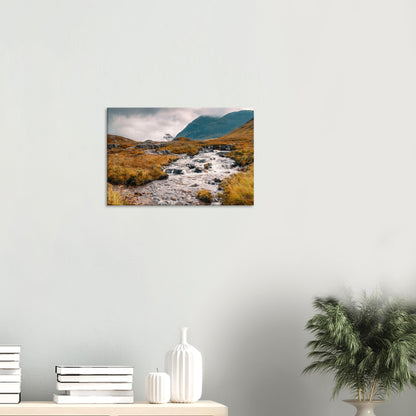Glencoe landscape featuring fast-flowing stream and misty mountains