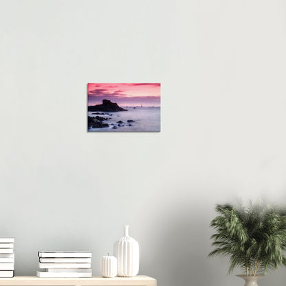 Wall art capturing Les Hanois Lighthouse in Guernsey at golden hour, with dramatic skies and gently lapping tides.