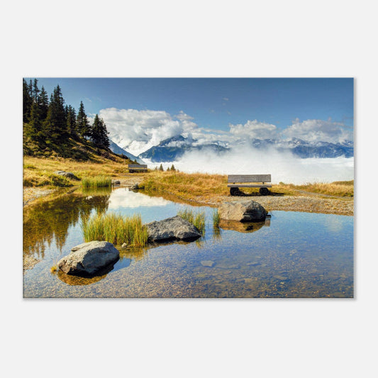 Reflective landscape canvas of the Panoramabahn in Austria with a peaceful bench, mirrored pond, and alpine clouds in soft motion.