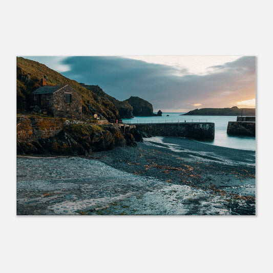 Serene view of a stone building overlooking Mullion Cove’s tranquil evening waters