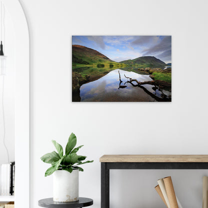 Canvas artwork of Crummock Water’s peaceful lake, with a solitary branch in the foreground and clear reflections of surrounding fells.
