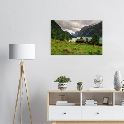 Canvas print depicting the quiet charm of Lodalen Valley, with serene lake reflections and rustic cabins beneath towering cliffs.