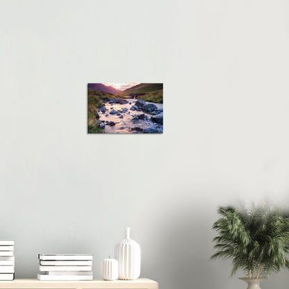 Lake District canvas print showing Honister Pass with golden hour glow, rugged landscape, and a tranquil river weaving through stones.